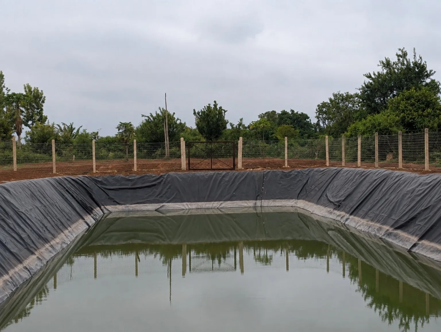 Lined water reservoir with perimeter fencing at Kinondo Farm